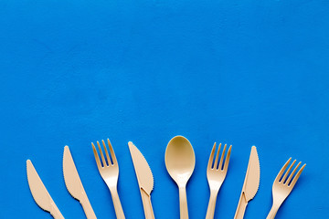 Plastic utilization concept with flatware on blue background top view mock up