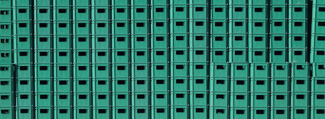 Green plastic crates for bottles stacked 