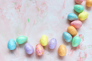 Multicolored eggs decoration on a pink background. Easter celebration concept. Top view, flat lay, copy space.