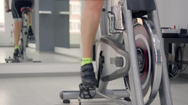 Close up of feet of a woman losing weight cycling on indoor bike