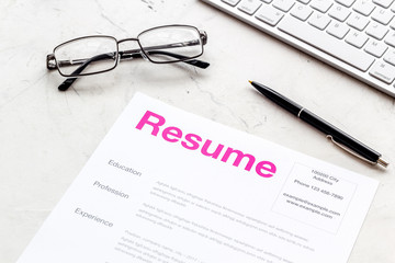 Create CV concept with pen, glasses, keyboard on white desk top view