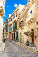 Beautiful narrow lane with typical Maltese architecture in Cospicua - one of the Three fortified Cities of Malta