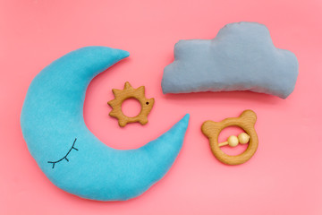 Moon pillow, clouds and toys for put baby in bed on pink background top view