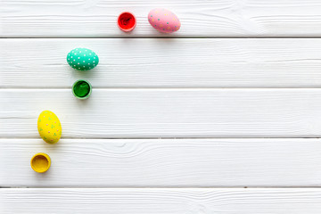 Colorful Easter eggs and paint for celebration on white background top view mock up