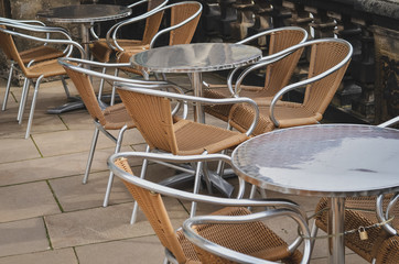 Row of empty tables with chairs in an outdoor cafe. Close up.
