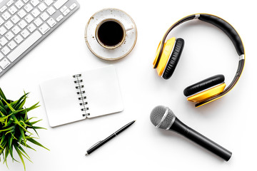 blogger work space with microphone, notebook, keyboard and headphones on white background top view...