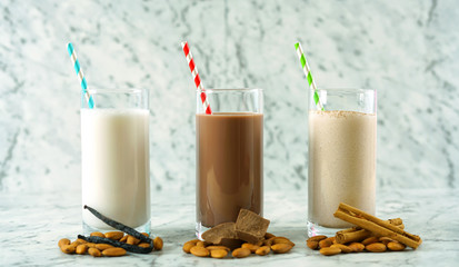 Nutritious vanilla, chocolate and cinnamon almond milk in glasses.