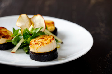 Scallops with black pudding and apple and pea shoots salad