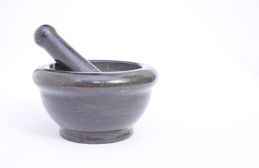 Black marble pestle and mortar on white background on left.
