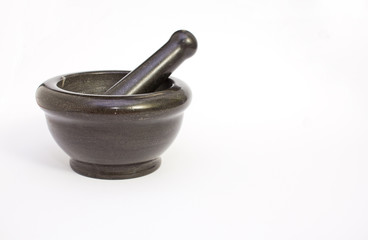Black marble pestle and mortar on white background on left.