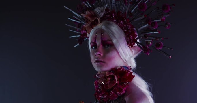 Fantasy floral elf fairy female posing in creative lighting. Body painting fashion project. Model and property released. 4K UHD RAW FOOTAGE