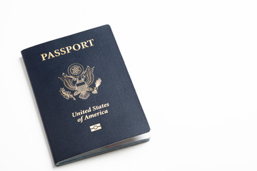 The iconic blue cover of an American passport deliberately and artistically set on a plain white background.