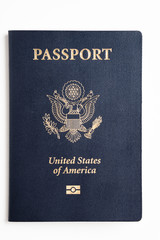 The iconic dark blue cover with gold stamp of an american passport deliberately and artistically set on a plain white background.