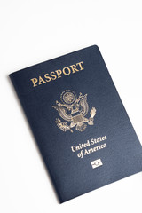 The iconic blue cover of an American passport deliberately and artistically set on a plain white background.