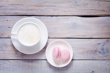 Cup Of Coffee With Milk And Macarons on wooden background