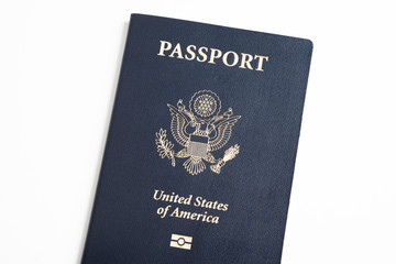 The iconic blue cover of an American passport deliberately and artistically set on a plain white background.
