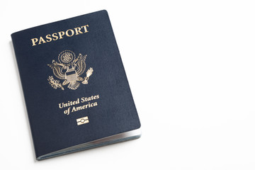 The iconic blue cover of an American passport deliberately and artistically set on a plain white...