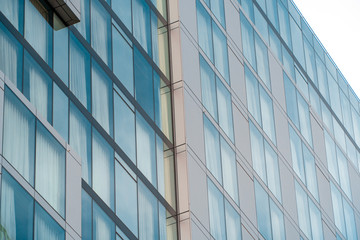 Fototapeta na wymiar Real estate lease concept. Blue windows of office building close up