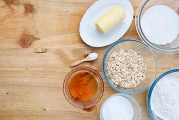 Ingredients for Anzac biscuits a traditional Australian cookie made for Anzac Day using butter, desiccated coconut, baking soda, rolled oats, golden syrup, sugar and flour. Flat lay, copy space