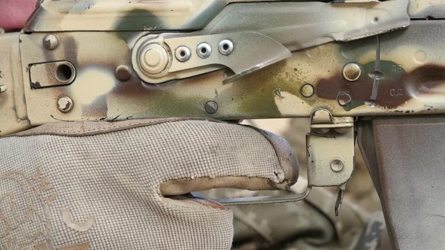 Military man targeting with his assault gun and putting his finger on the trigger   