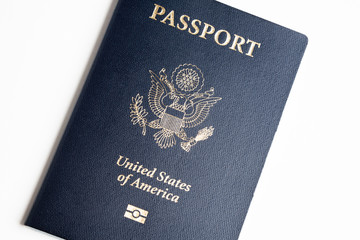 The iconic blue cover of an American passport deliberately and artistically set on a plain white background.