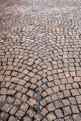 Wet cobblestone street in a swirl pattern for background or texture.