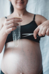Pregnant woman cutting a condom