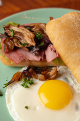 Ciabatta with oyster mushrooms, ham and fried egg for breakfast