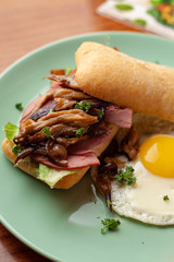 Ciabatta with oyster mushrooms, ham and fried egg for breakfast