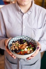 Rich oatmeal with fresh berries, nuts, fruit and peanut butter
