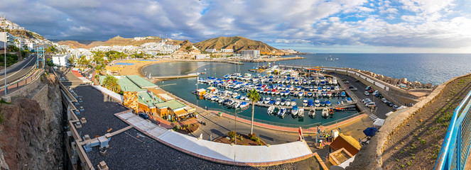 Panoramic aerial view of sea port and small bay of Puerto Rico de Gran Canaria holiday resort. Gran Canaria island, Spain - obrazy, fototapety, plakaty