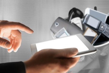 Hand with phone and rubbish bin full