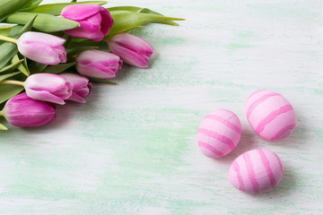 Easter pale pink striped painted eggs and tulips.