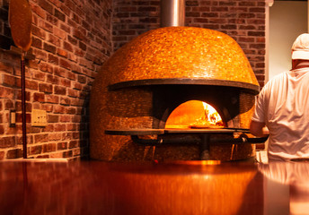 Pizza being put into a brick oven fireplave