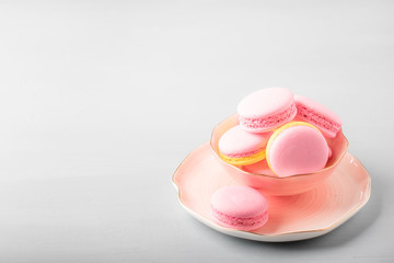 Pink yellow macaroons cakes on gray blue table background, place for text, trendy minimalism style, selective focus