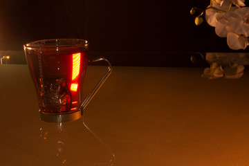 Cup of hot tea with teapot inside it resting in hot water to obtain essence of Jamaica adorns a...