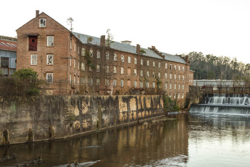 Fototapeta na wymiar Old riverside factory left abandoned