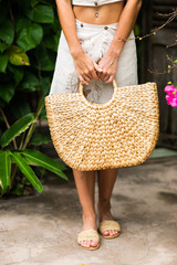 Woman hands with straw bag.