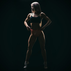 Silhouette of young fit woman on black