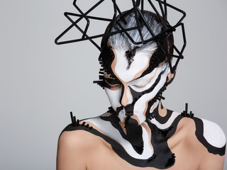 Female model with creative abstract makeup in futuristic hat
