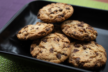 Delicious chocolate chip cookies on black plate