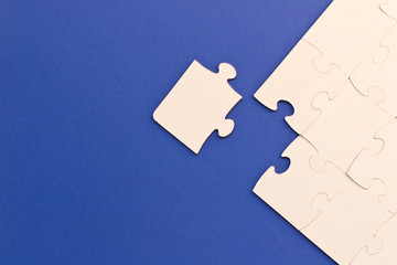 White jigsaw puzzles on blue background. The concept of development of thinking. The concept of...
