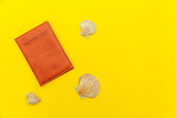 Travel vacation summer weekend sea adventure trip journey ticket tour concept. Minimal simple flat lay with passport and shell on yellow trendy modern background. Tourist essentials
