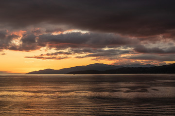 Sunset over the sea with mountains in the back