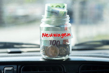 Ein Einmachglas mit Euro Geldscheinen und Münzen als Erspartes für Neuwagen