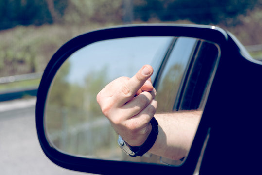 Ein Mann zeigt den Mittelfinger aus dem Auto Fenster
