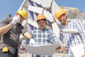 Engineer architect and worker operation control demolish old building.