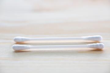 Two white plastic cotton buds on wood table texture background, Close up & Macro shot, Selective focus, About Cleaning Body, Healthcare concept