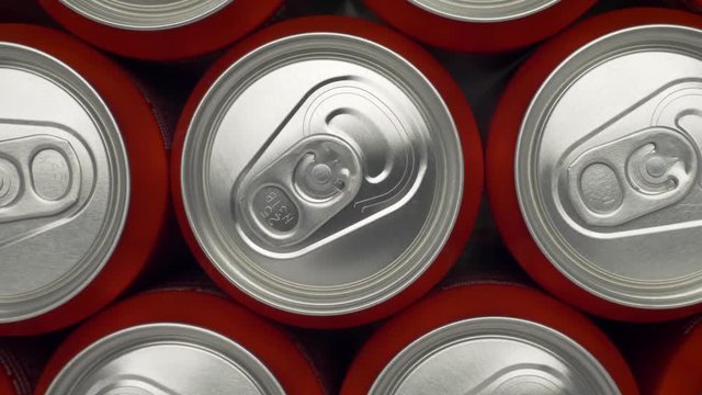 refrigerator clogged with cans of soda. aluminum cans of beverage lie in an filled fridge. Cans with beer on a shelf in the refrigerator. dolly slow motion shot close up medium