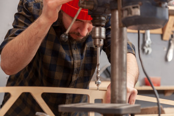 Arms of worker  carpenter using electric drilling machine,  closeup. Manual job DIY inspiration improvement job fix shop helmet joinery startup idea industrial education profession career concept